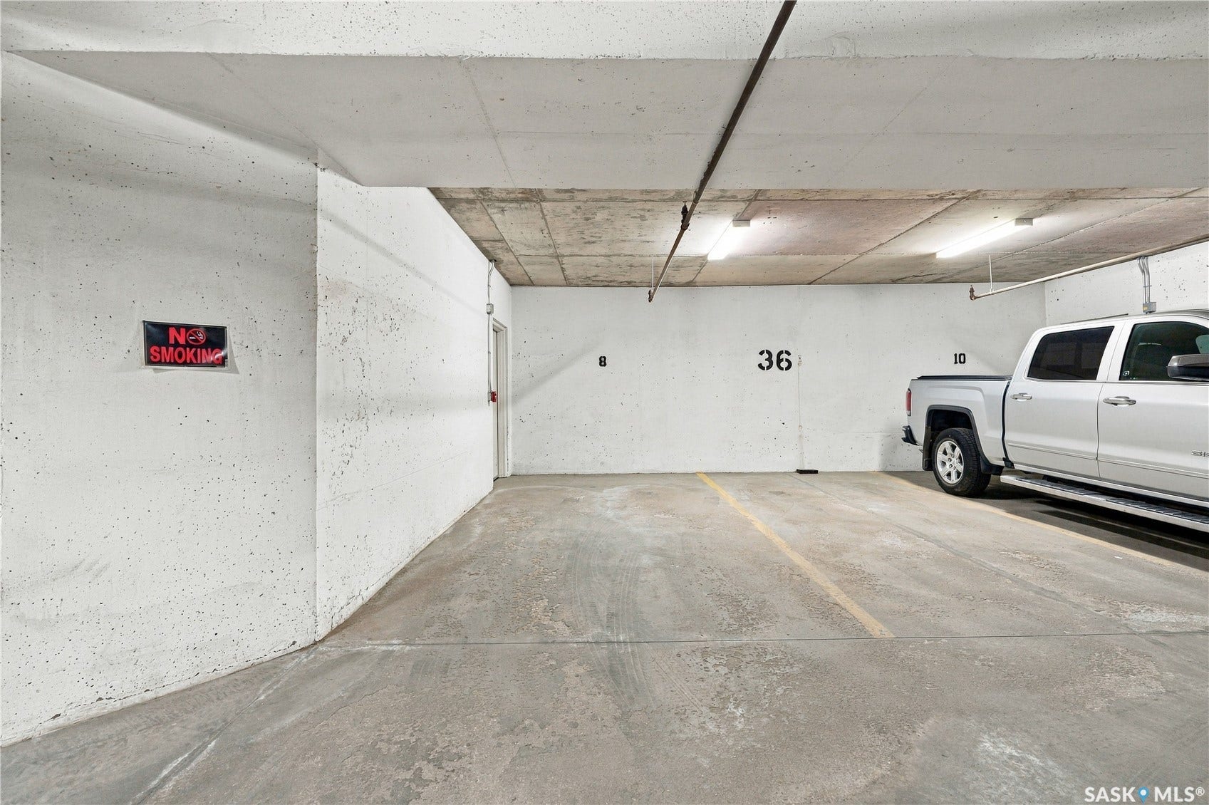 Designated parking space with concrete flooring and overhead lighting