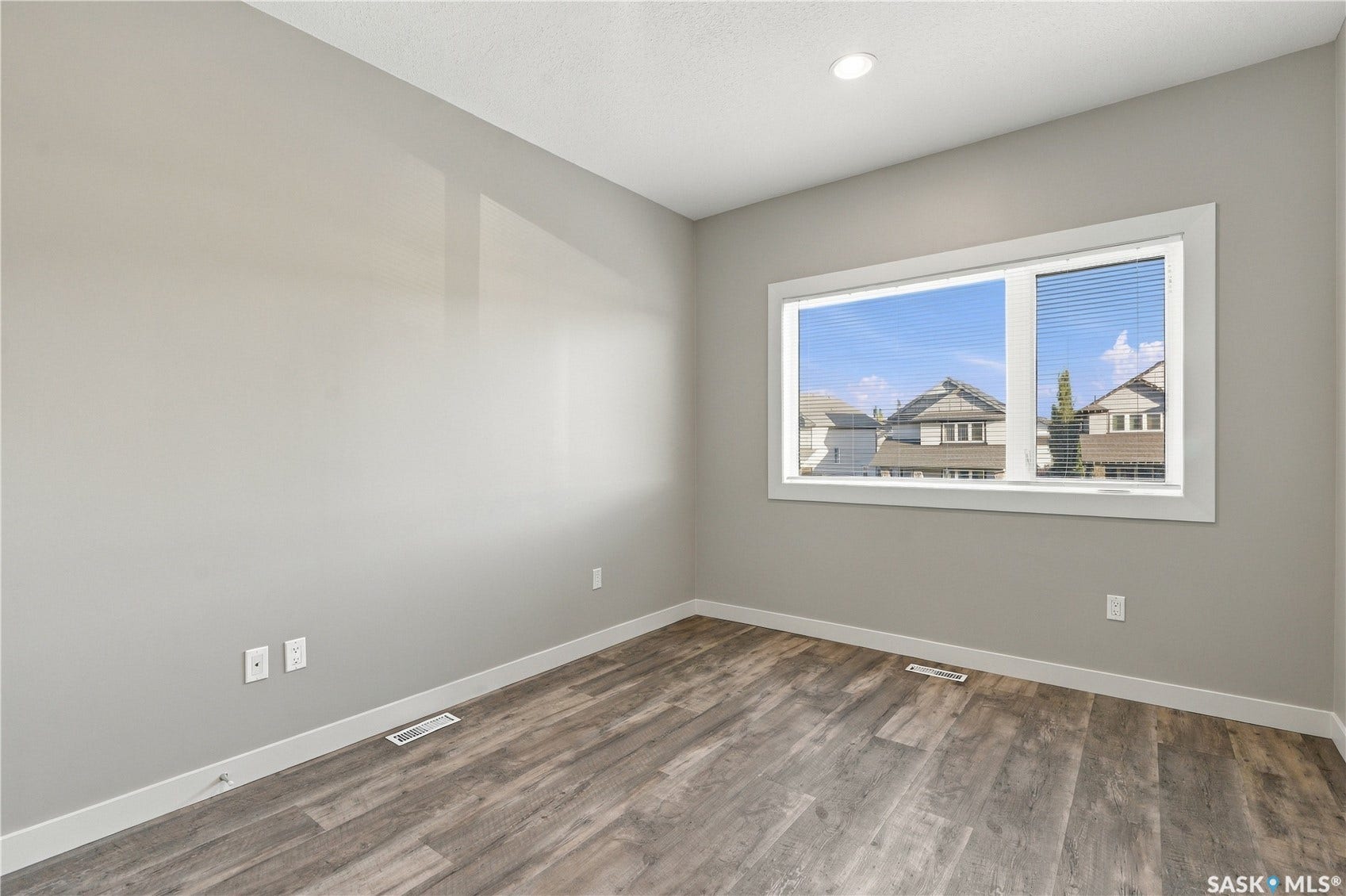 Recessed ceiling lighting, wood-finish flooring, and a large window with horizontal blinds
