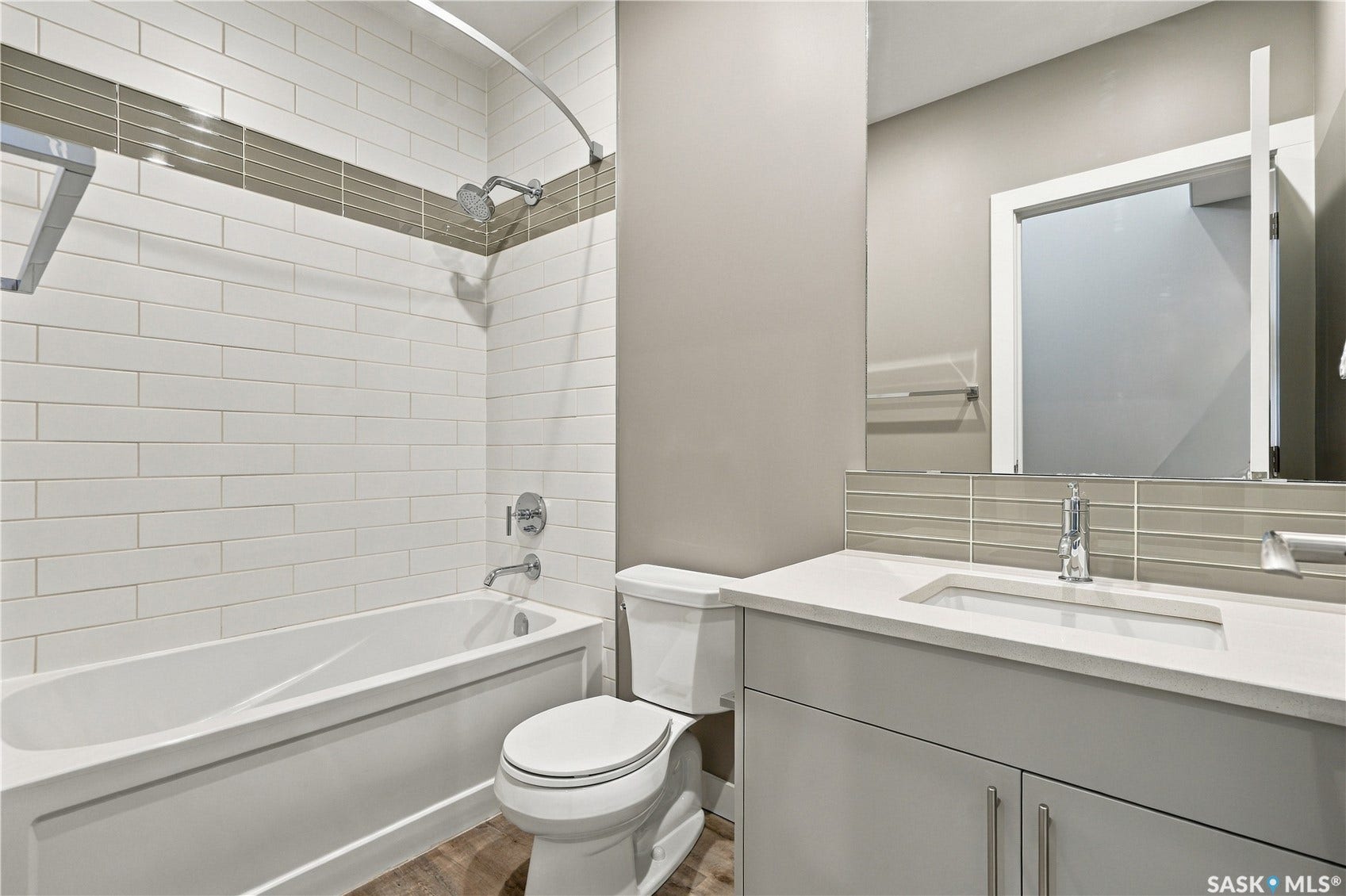 White subway tile shower surround with a decorative accent band