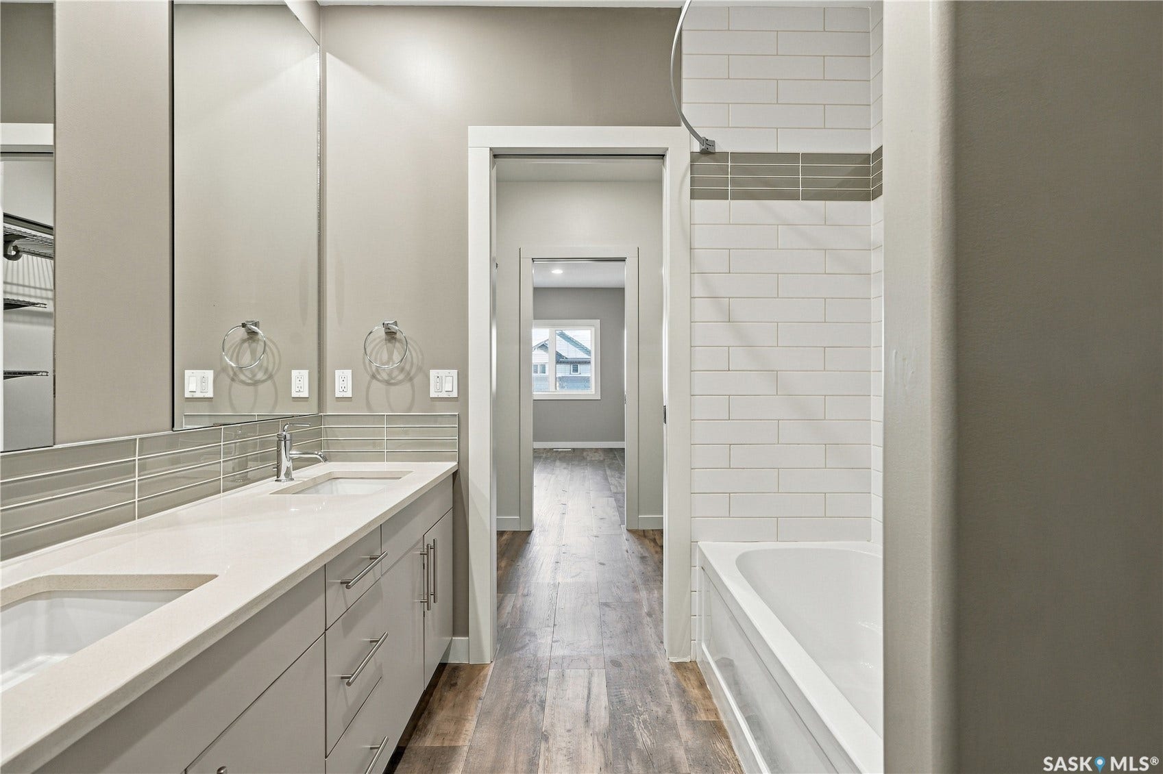 Double vanity with an integrated white countertop, undermount sinks, and chrome faucets