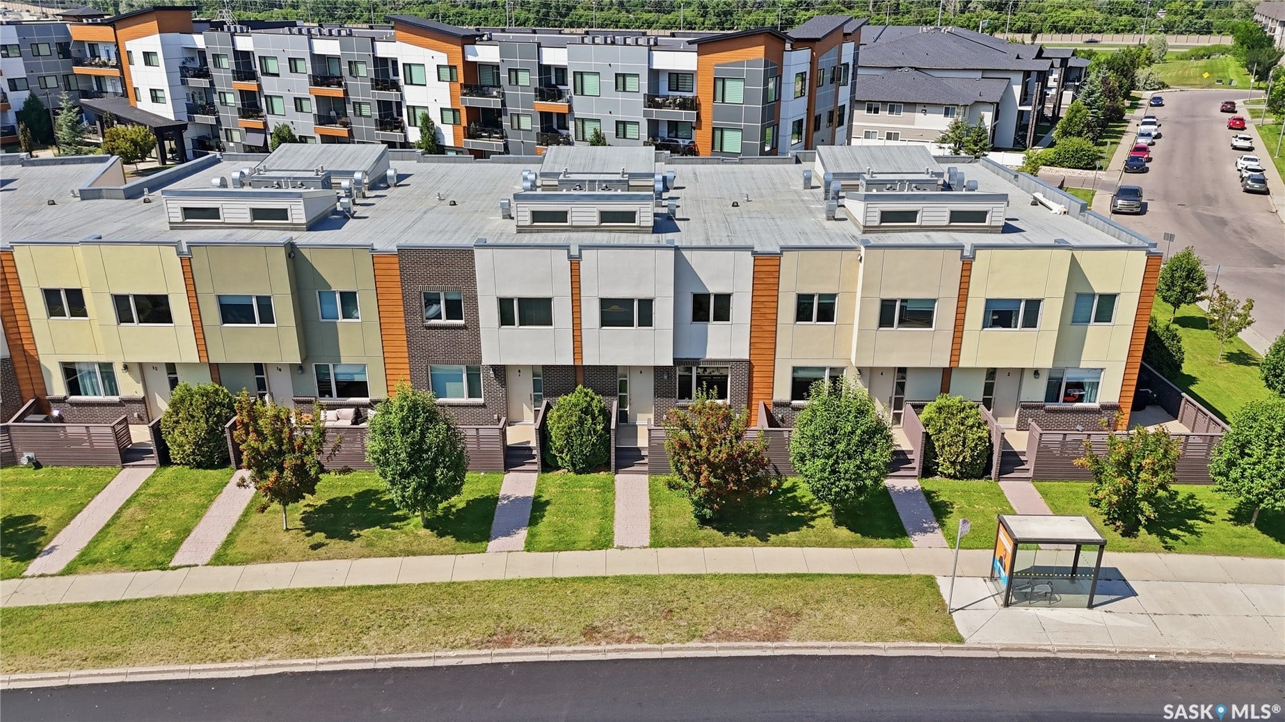 Modern townhome exterior with varied siding, individual patios, and landscaped front yards