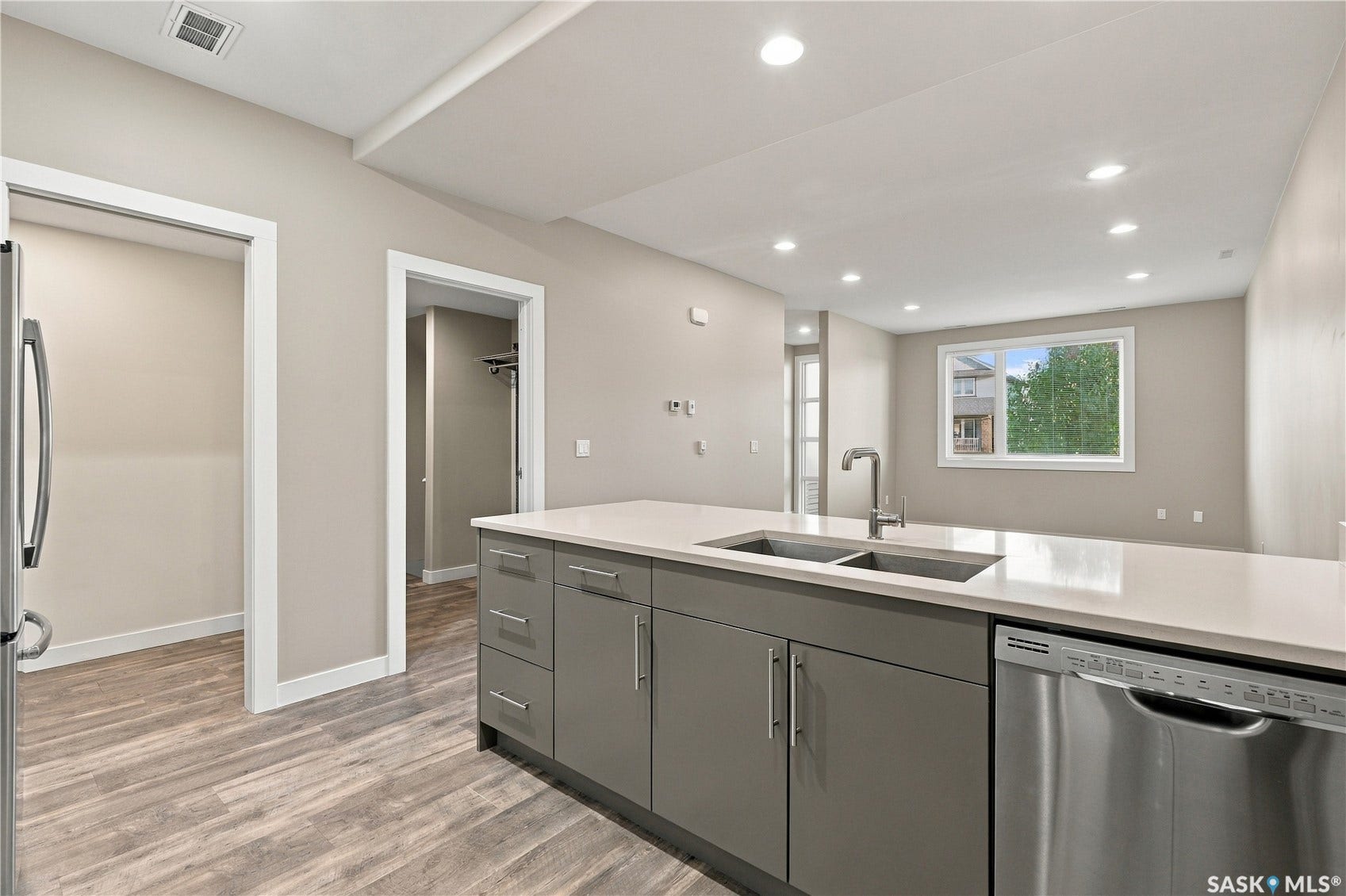 Kitchen island with an undermount dual-basin sink, stainless steel faucet, and light-toned countertop