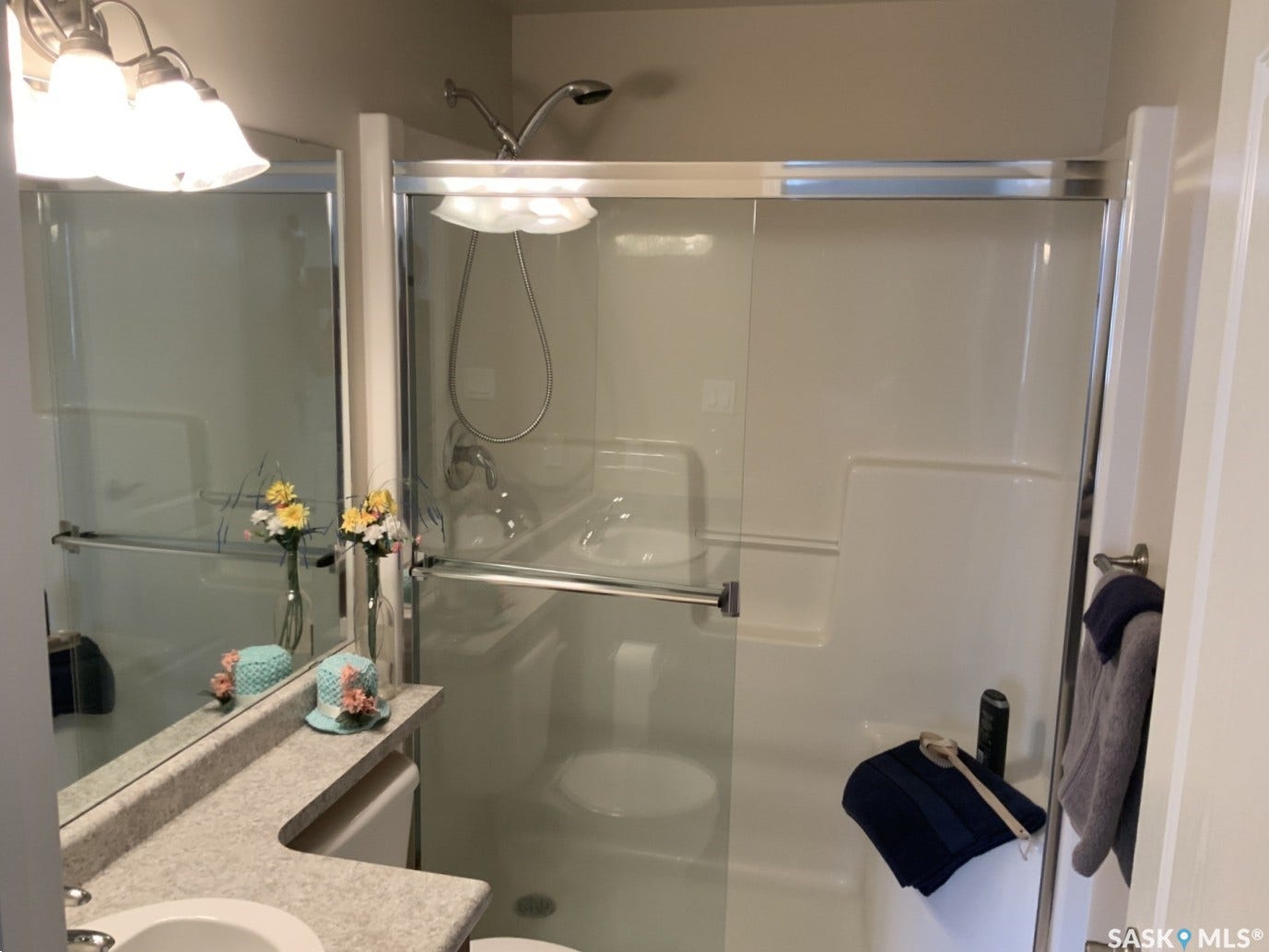 Shower enclosure with clear glass doors and a built-in shelf