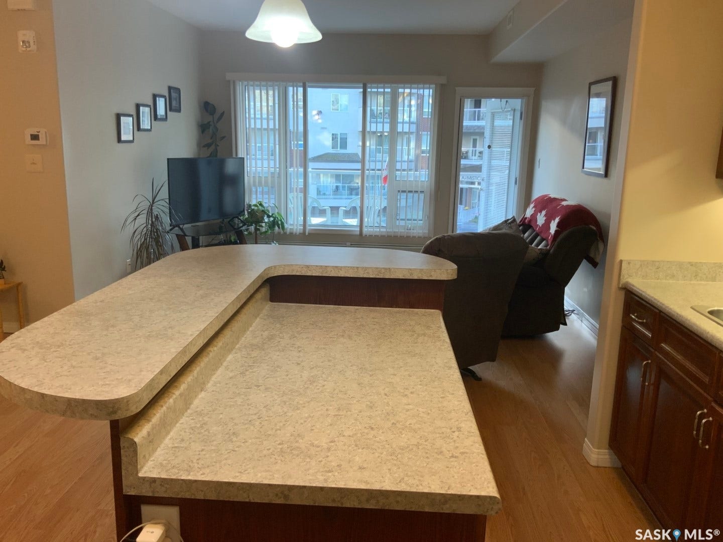 Expansive counter space with a breakfast bar, wood-finish flooring, and a large sliding glass door with a balcony