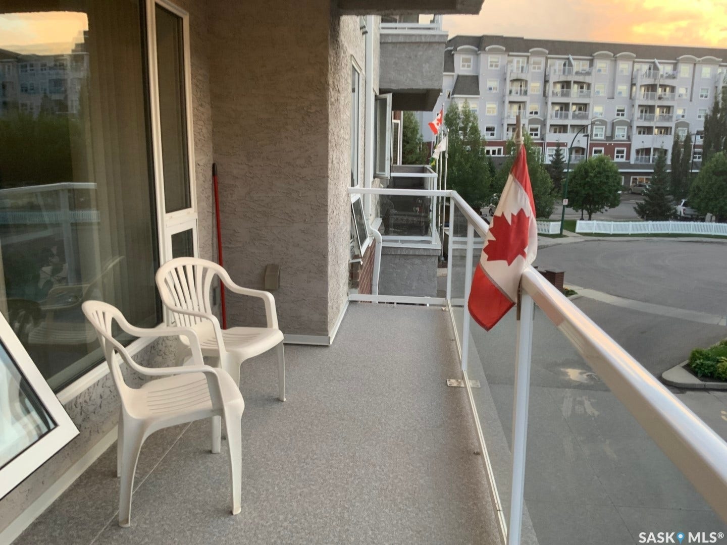Balcony with textured exterior wall, glass and metal railings, and a durable speckled floor