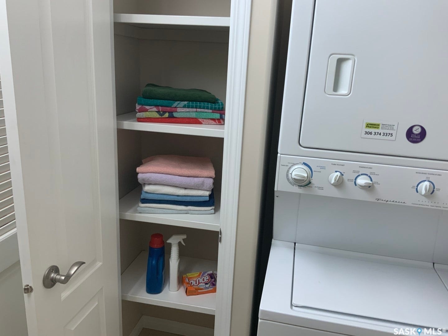 Integrated stackable laundry appliances with adjacent built-in shelving