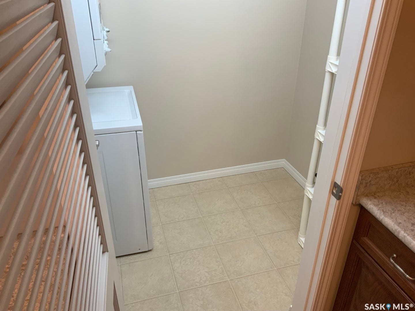 Tile flooring, light neutral wall color, white baseboards, white appliances