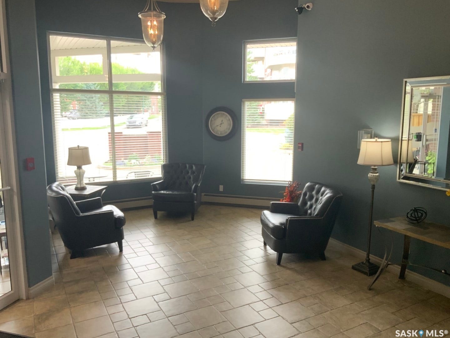 Patterned tile flooring, multiple large windows, and overhead pendant lighting fixtures