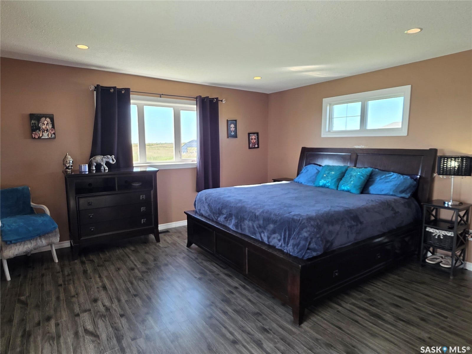 Recessed lighting, laminate flooring, and multiple windows with white trim