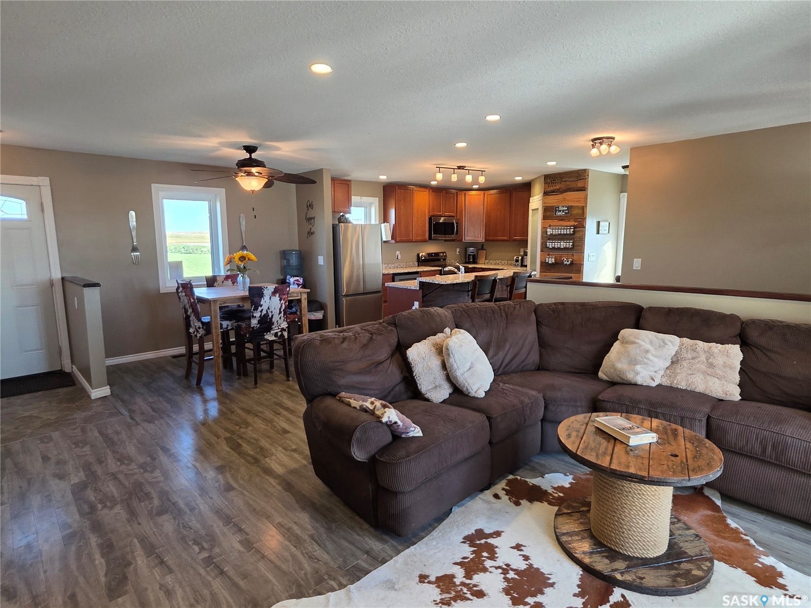 Open-concept living area featuring laminate flooring, & recessed lighting
