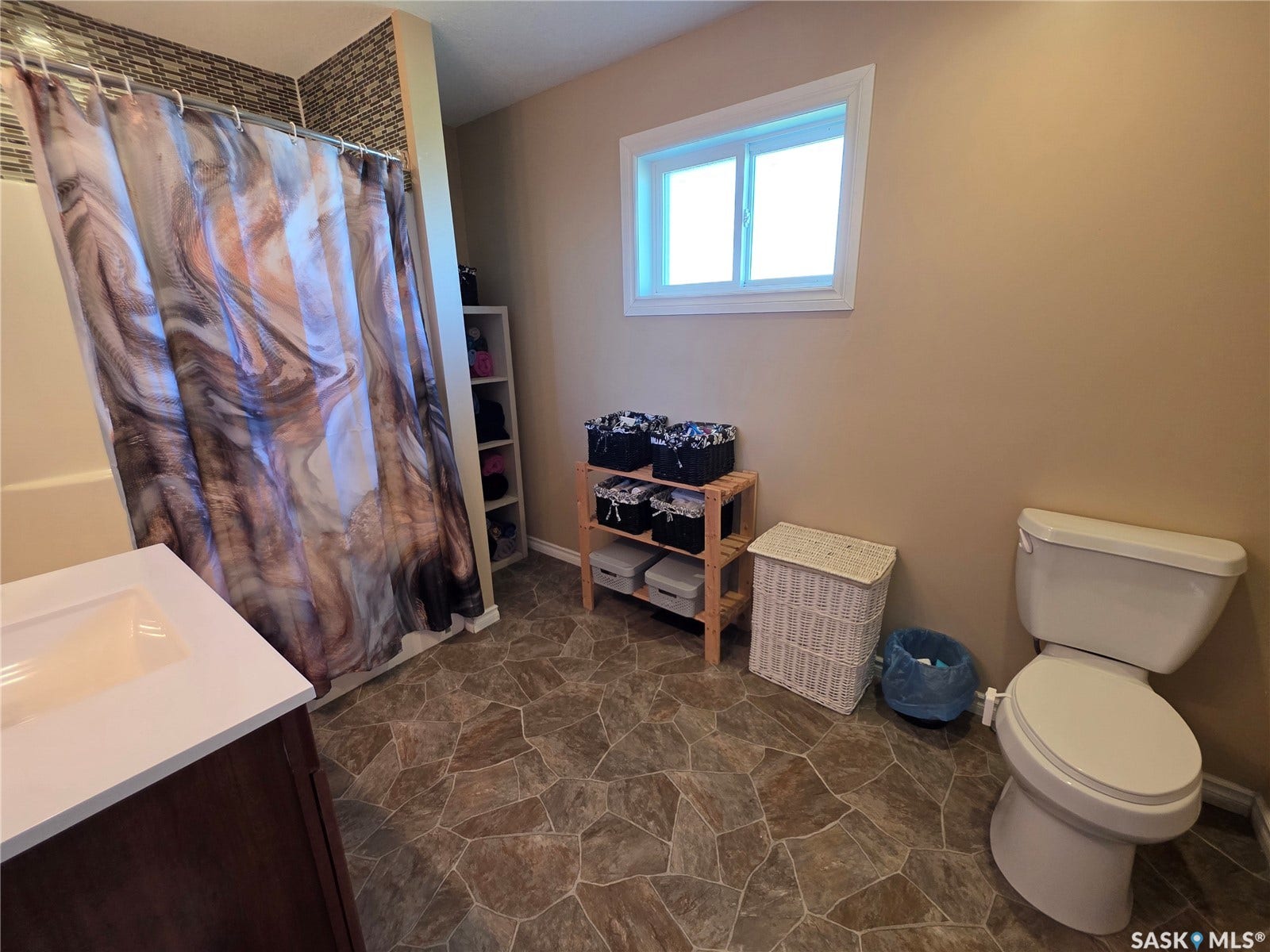 Bathroom featuring lino flooring, a single vanity with a white countertop, and a shower with mosaic tile surround on top