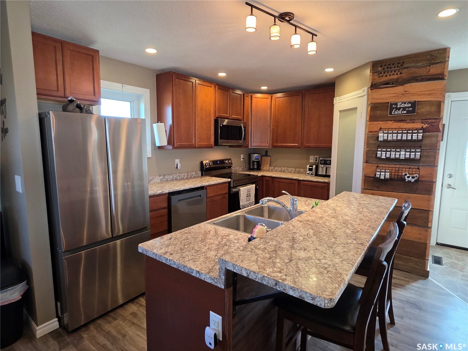 Kitchen featuring a dual-basin sink, stainless steel appliances, recessed lighting, and laminate flooring