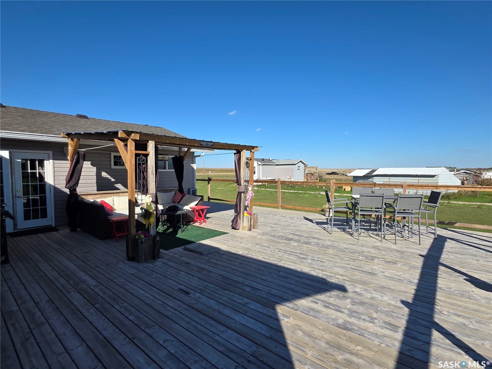 Expansive wood deck with a covered pergola featuring a metal roof