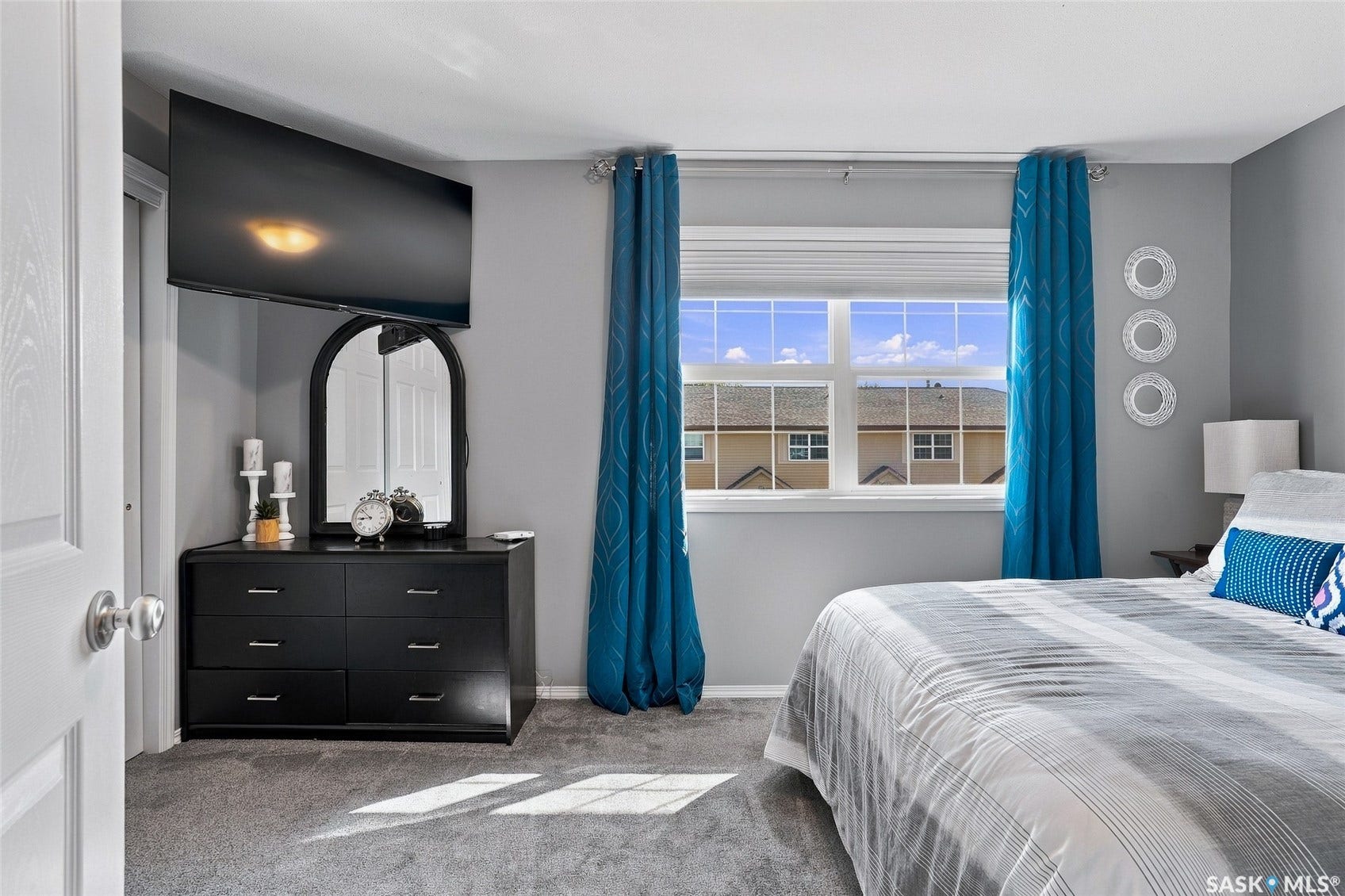 Window featuring white blinds and decorative drapes
