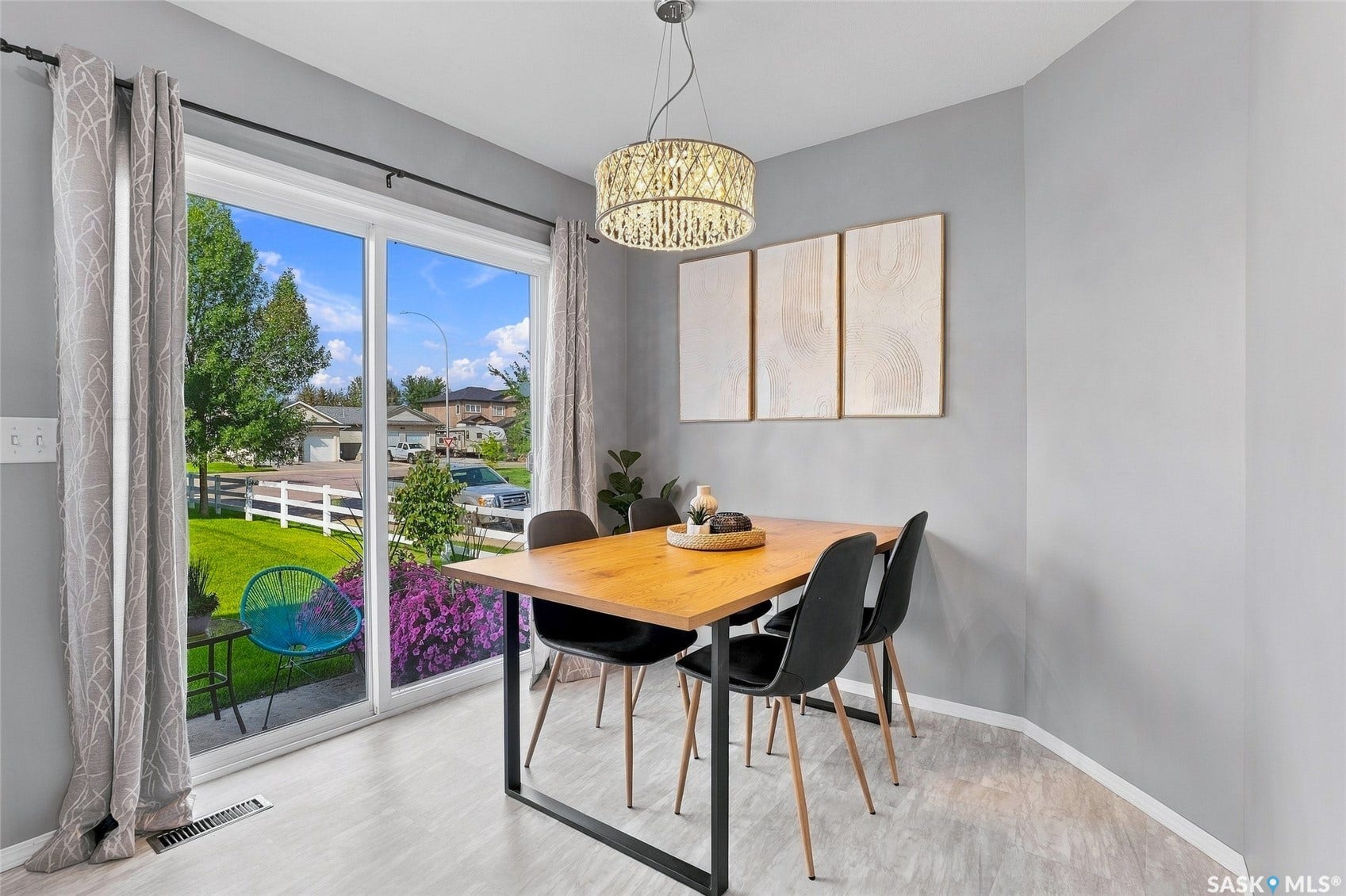 Sliding glass patio door, wood-finish flooring, and a decorative pendant light fixture