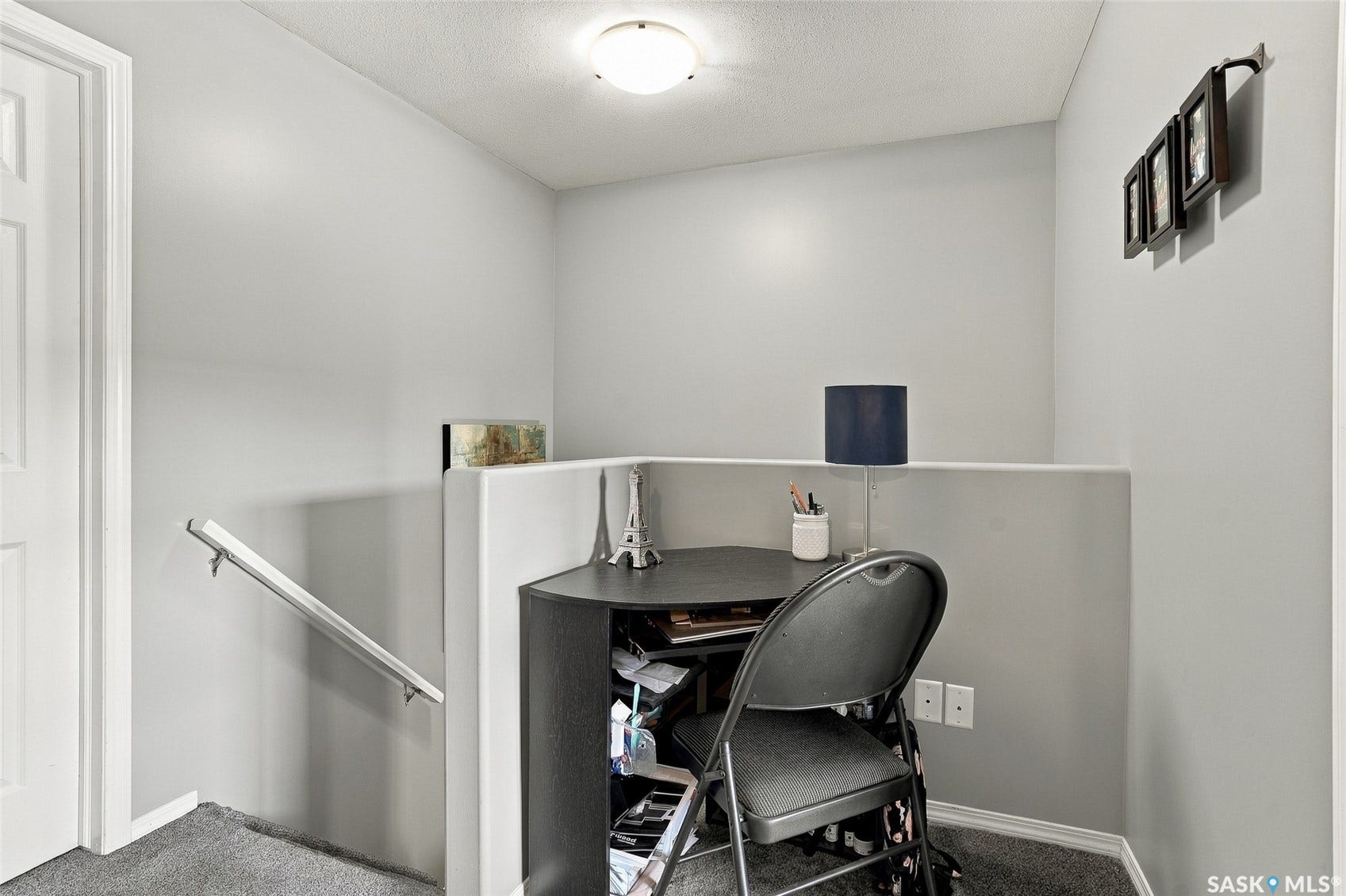 Integrated corner desk with storage, neutral wall paint, and overhead flush-mount lighting