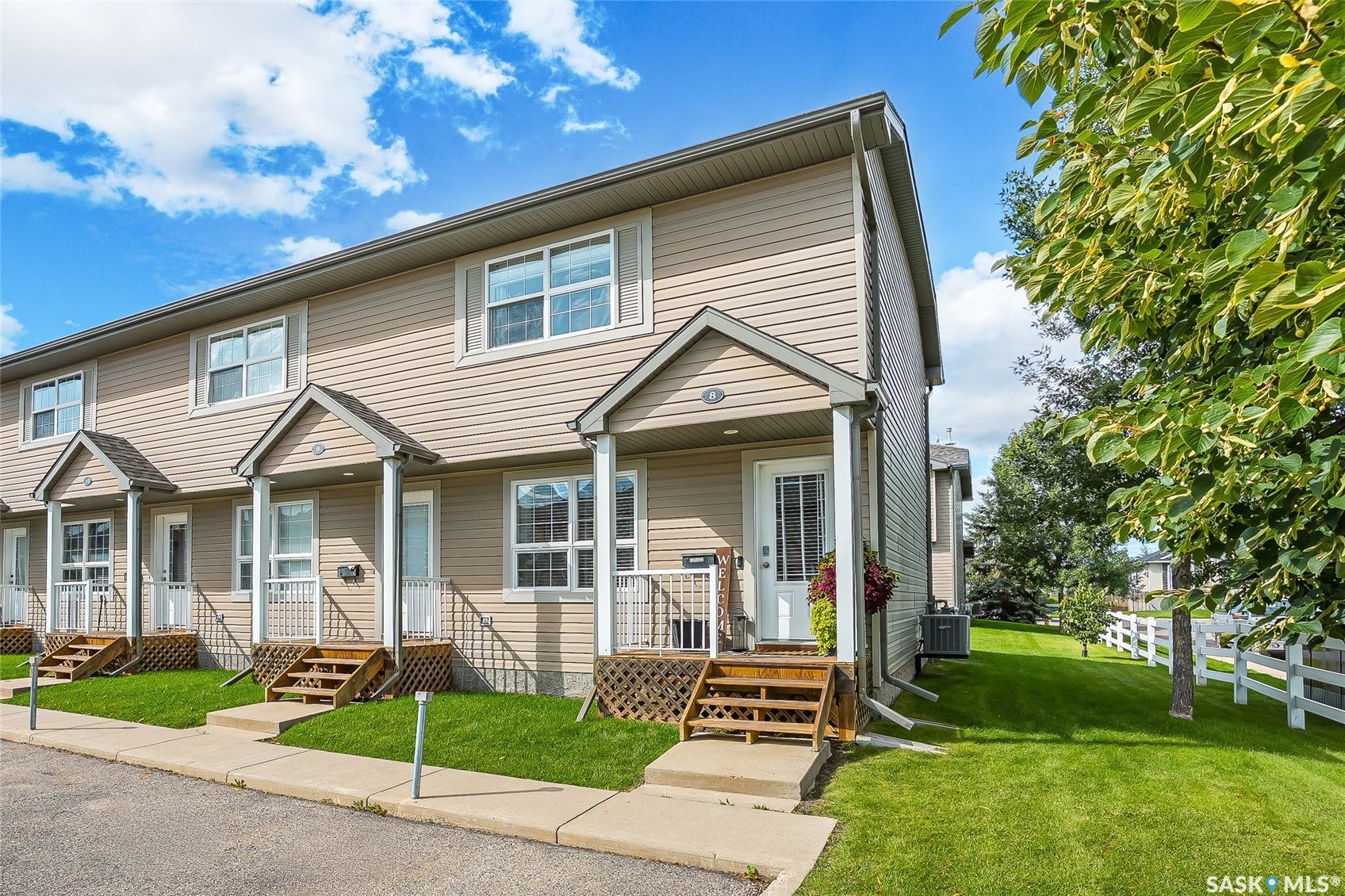 Two-story townhome with light-toned siding and white trim