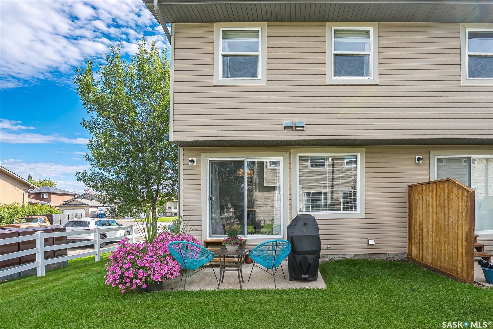 Rear exterior with beige siding, white window frames, and a sliding glass door