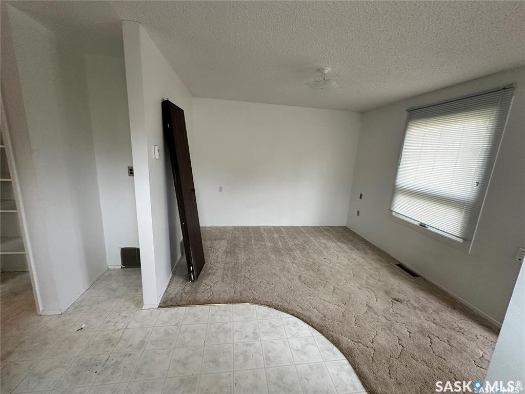 White painted walls with textured ceiling and a built-in ceiling light fixture