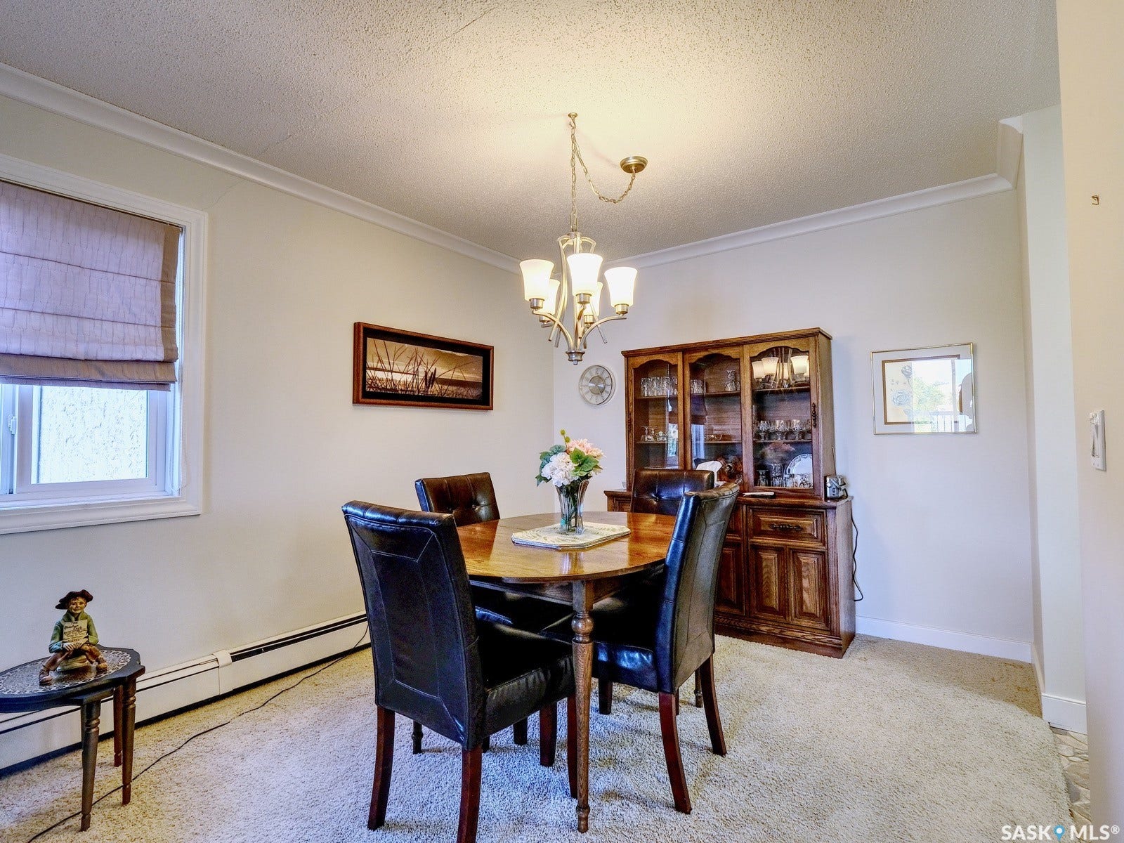 305 1st Street W, #302, Rosetown SK S0L 2V0 Recessed window with a neutral-toned roman shade, a multi-bulb chandelier, and crown molding