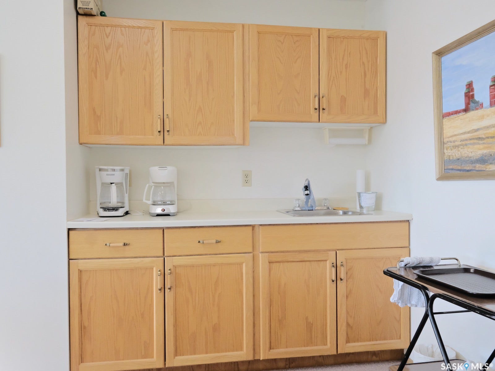 305 1st Street W, #302, Rosetown SK S0L 2V0 Light-toned wood cabinetry with brushed nickel hardware, white countertop, and a stainless steel sink with a single-handle faucet