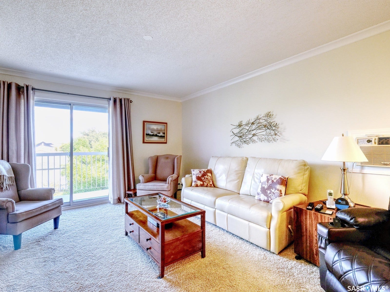 305 1st Street W, #302, Rosetown SK S0L 2V0 Sliding glass door leading to a balcony, light-toned wall paint, crown molding, and textured ceiling