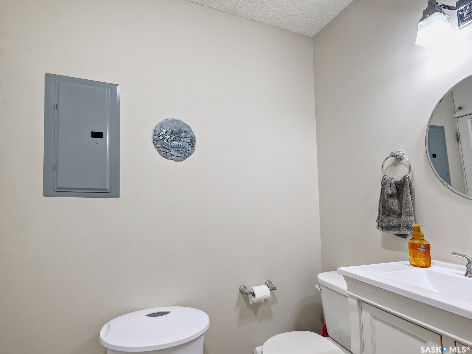 305 1st Street W, #302, Rosetown SK S0L 2V0 White vanity with integrated sink, chrome faucet, and circular mirror