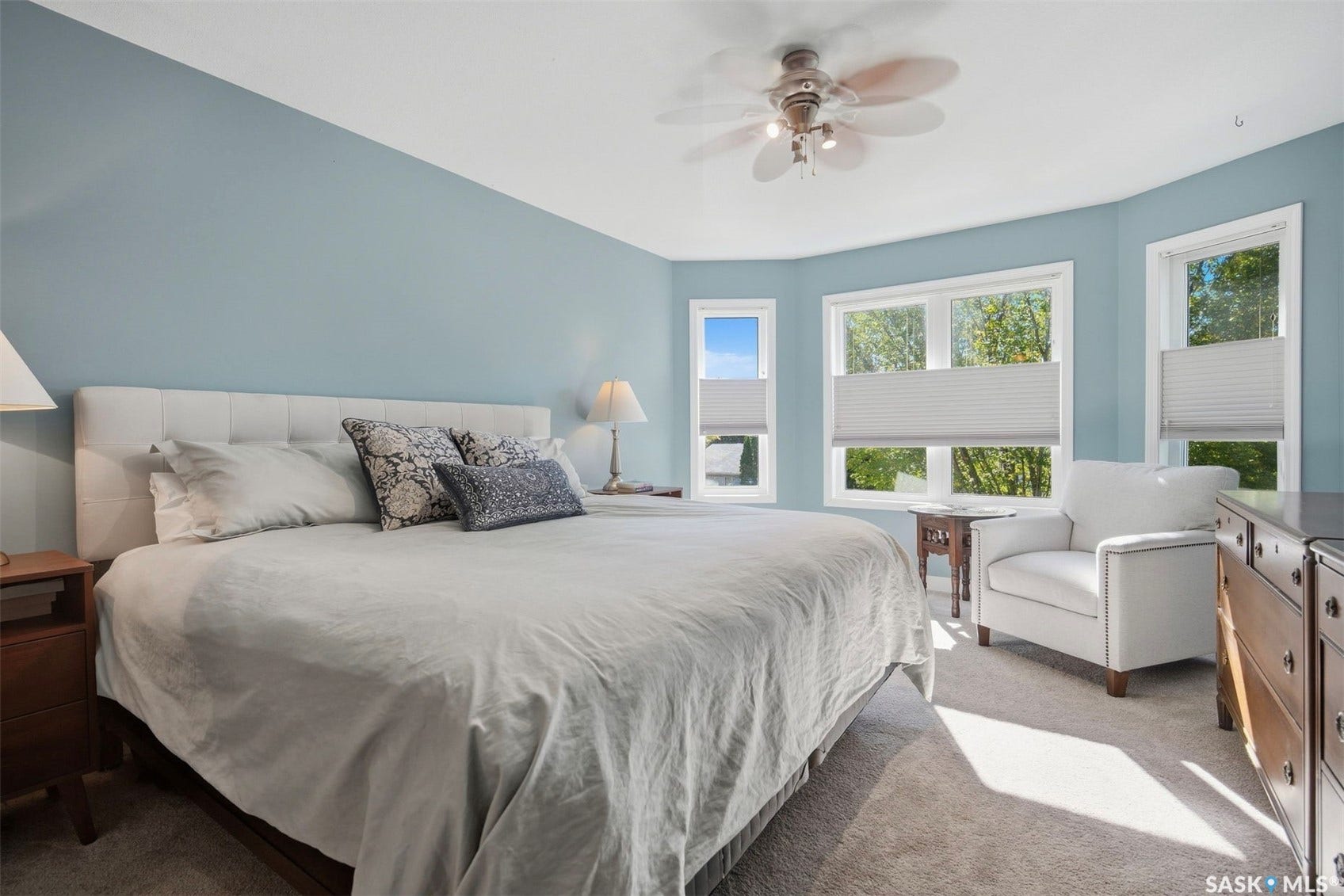 Tray ceiling with a ceiling fan, recessed lighting, carpet flooring, multiple windows, and light blue walls