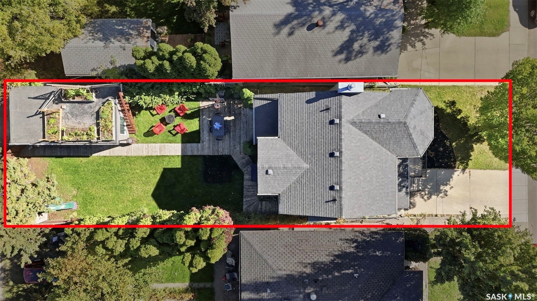 Expansive backyard featuring a manicured lawn, a multi-level deck, and a detached structure with a green roof