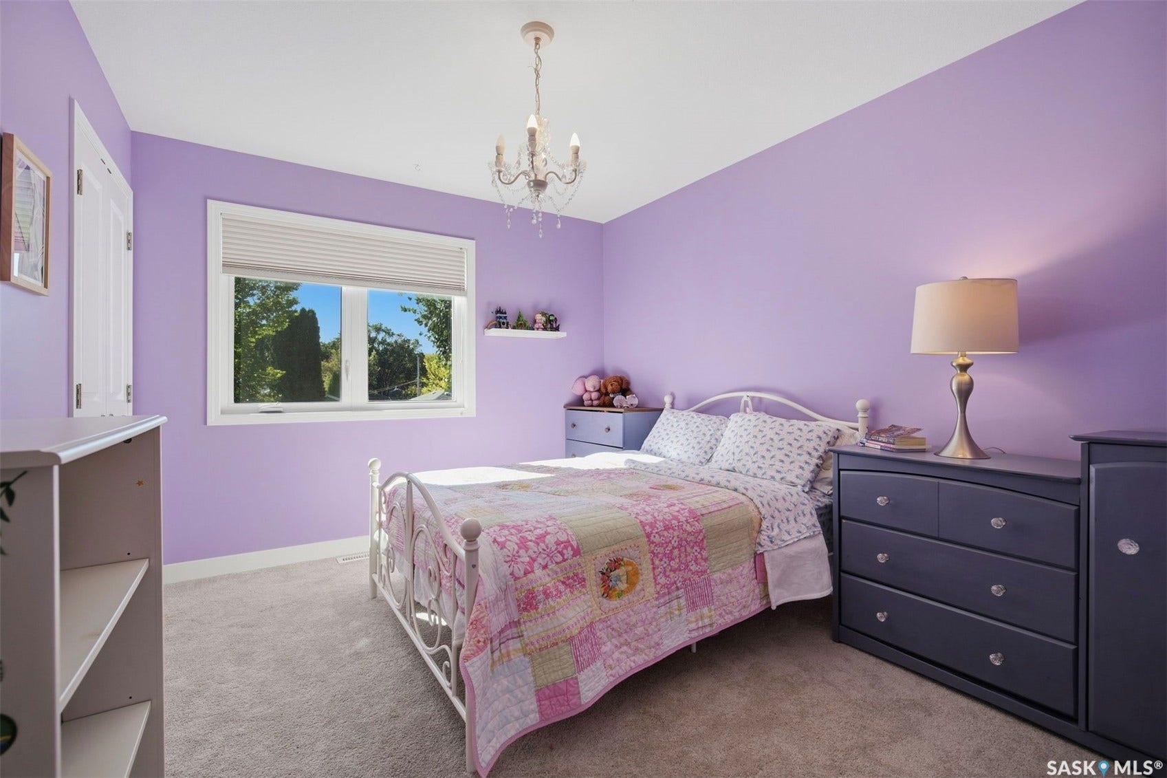 Recessed window with white blinds, wall-mounted shelving, and a chandelier light fixture