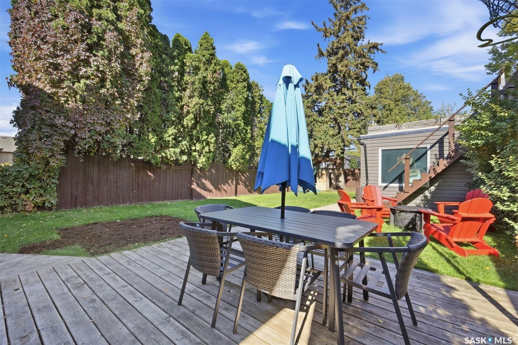 Wood-finish deck with a designated outdoor dining area and additional seating space