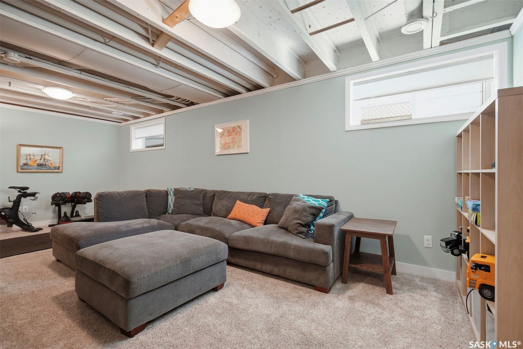 Recessed ceiling, exposed joist ceiling, carpeted flooring, two flush-mount light fixtures, window with blind