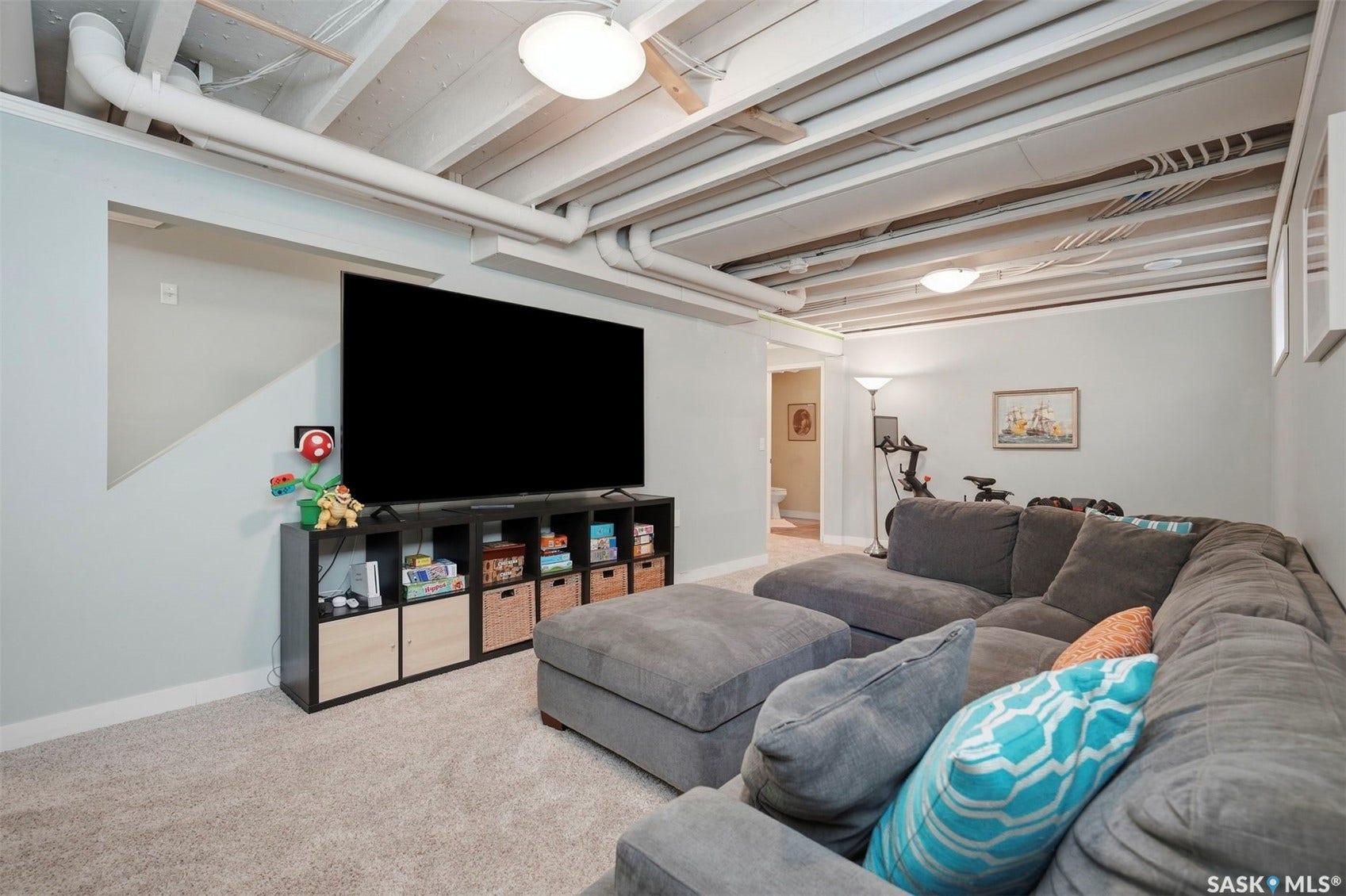 Finished lower-level space featuring exposed beam ceiling, recessed lighting, and carpet flooring