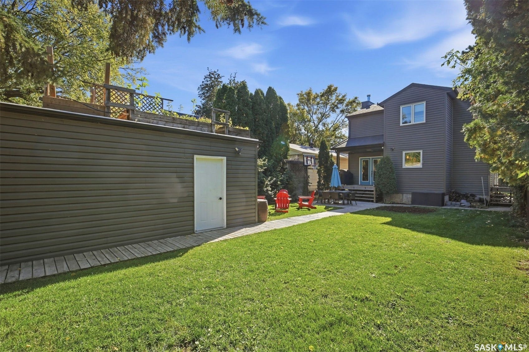 Expansive green lawn with a paver pathway leading to a detached structure