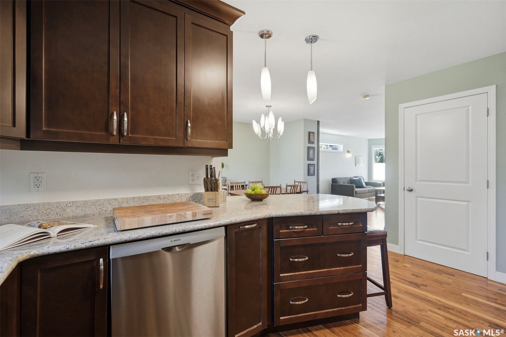 Kitchen featuring wood-finish flooring, dark wood cabinetry, light-toned countertops, and stainless steel appliances