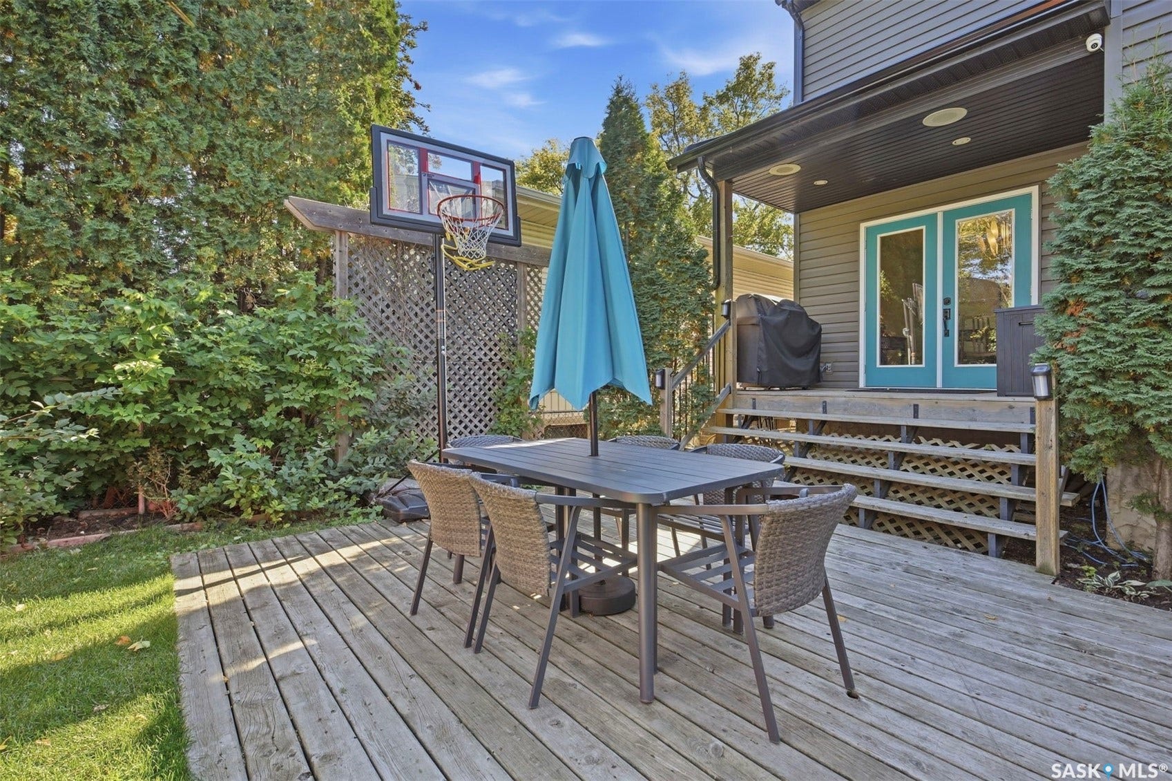 Expansive wooden deck with a covered porch featuring recessed lighting and french doors