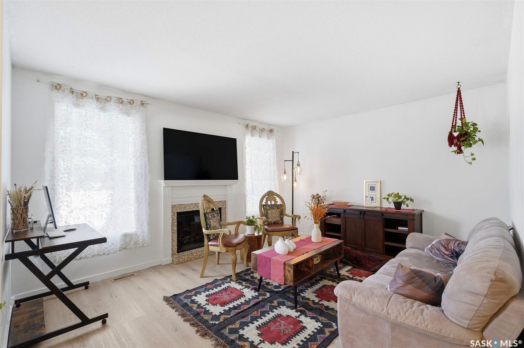 Living area featuring a fireplace with a decorative surround, wood-finish flooring, and white walls