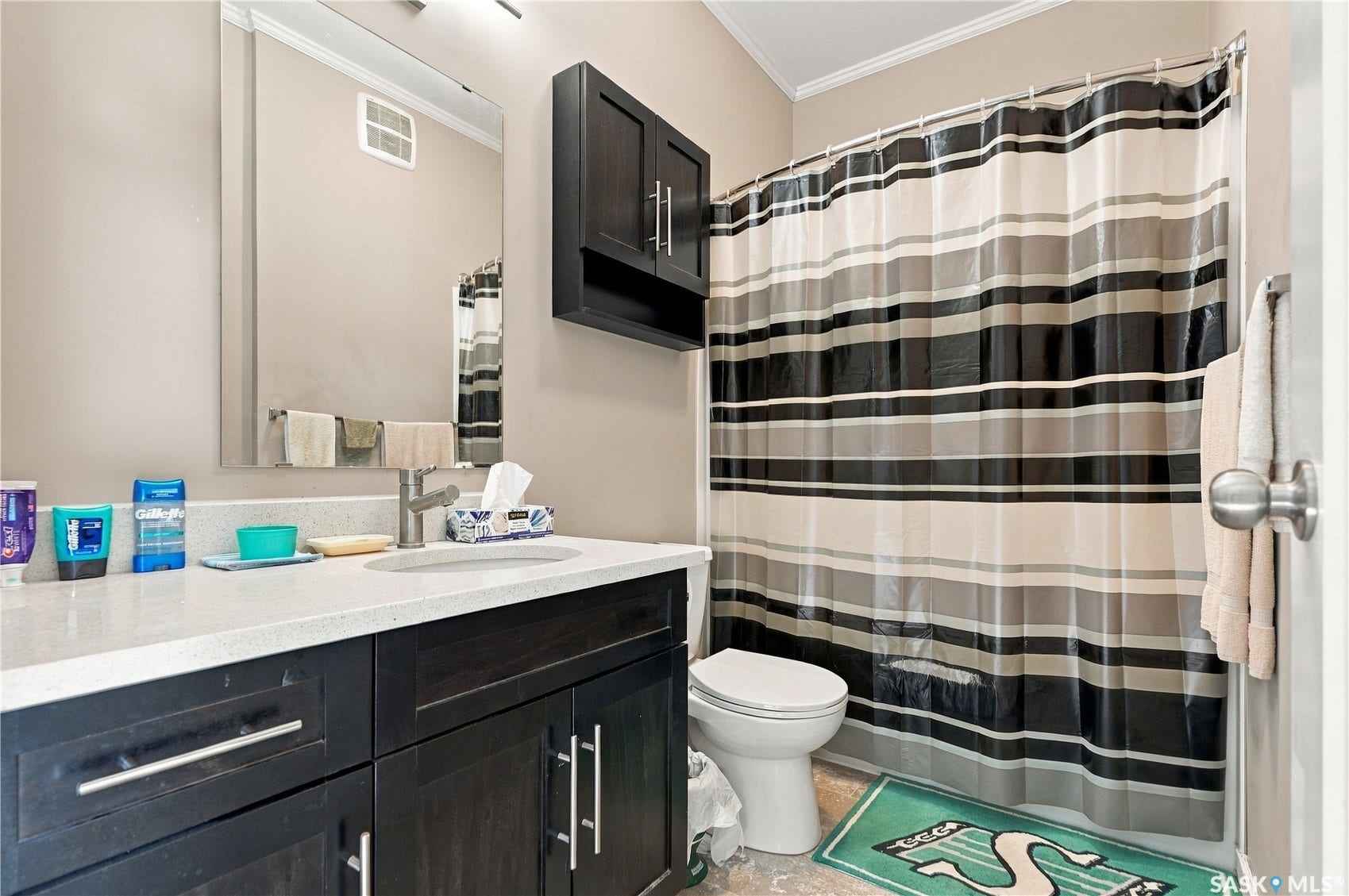 Vanity with a light-colored countertop, undermount sink, and dark wood-finish cabinetry