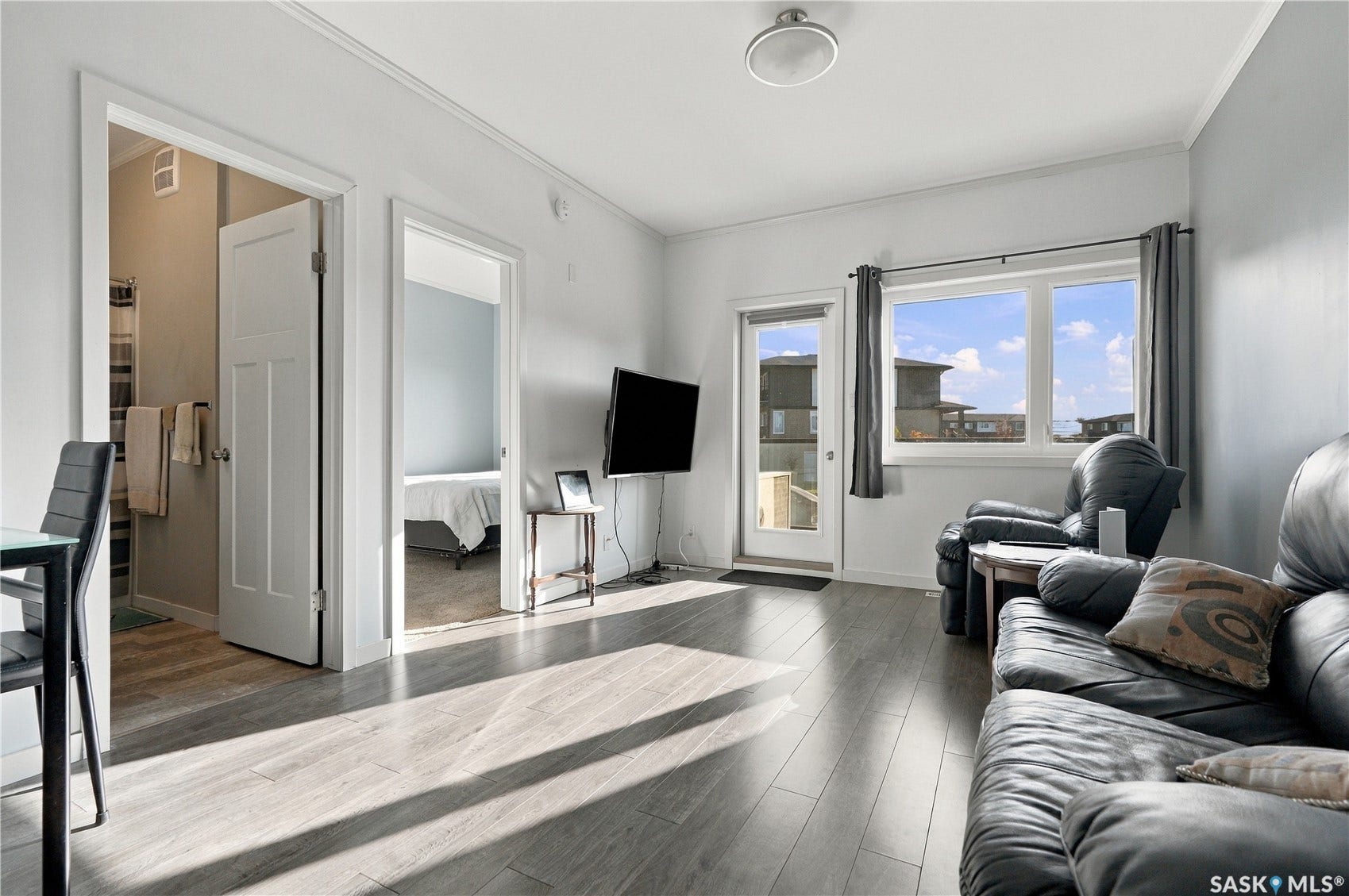 Recessed lighting, light wood-finish flooring, white trim, and a glass-paneled door