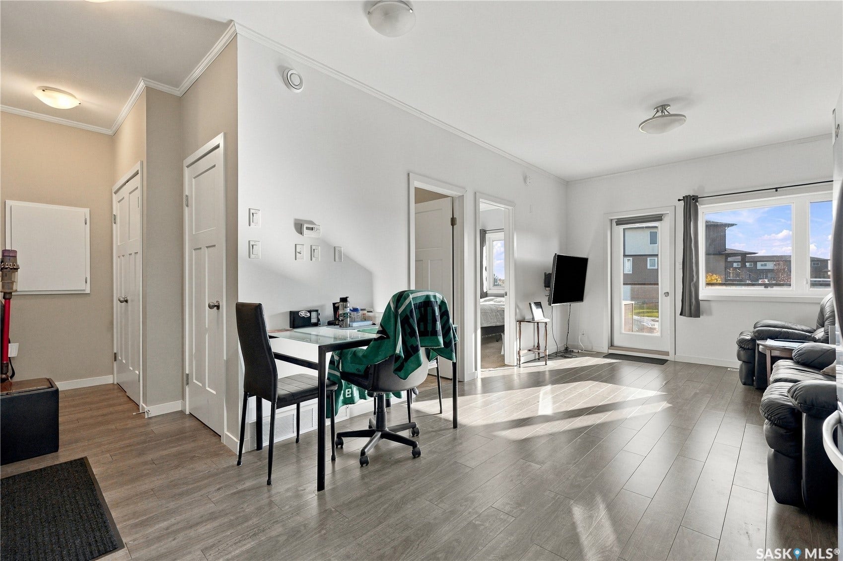 Light wood-finish flooring throughout, white walls, and white trim