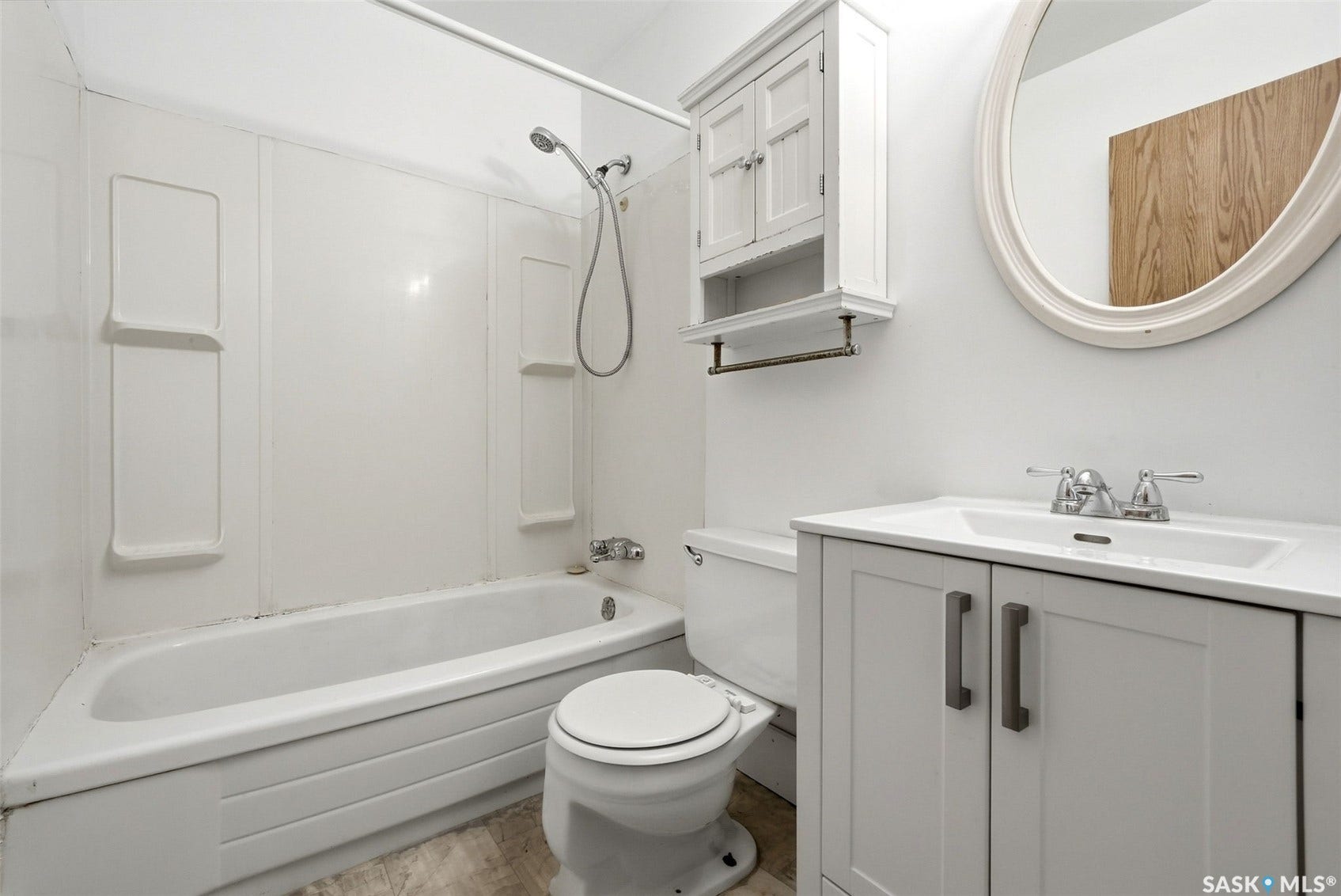 White shaker-style vanity with integrated sink, chrome faucet, and rectangular pulls