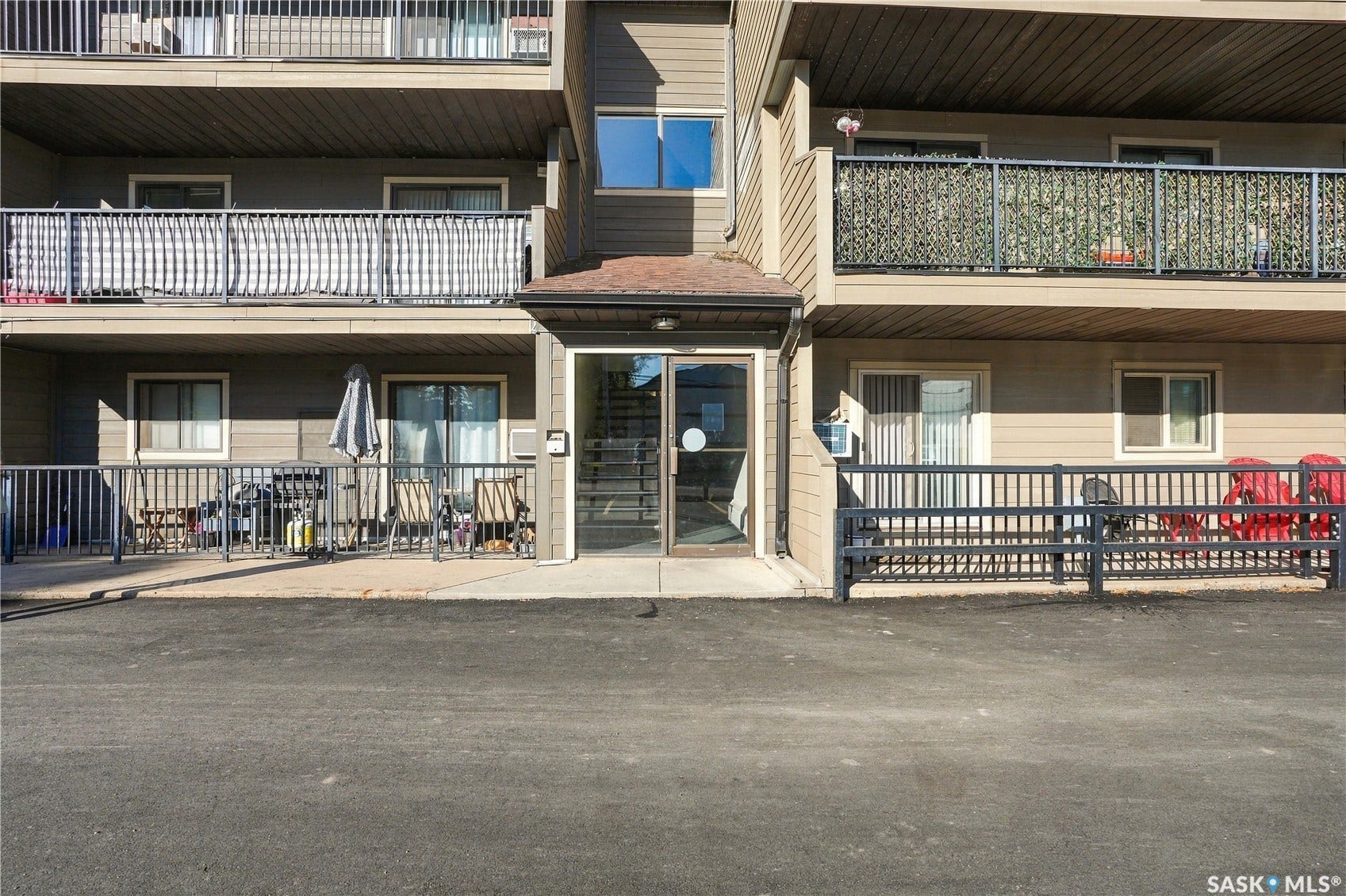 Multi-story building exterior with horizontal siding and multiple balconies with metal railings
