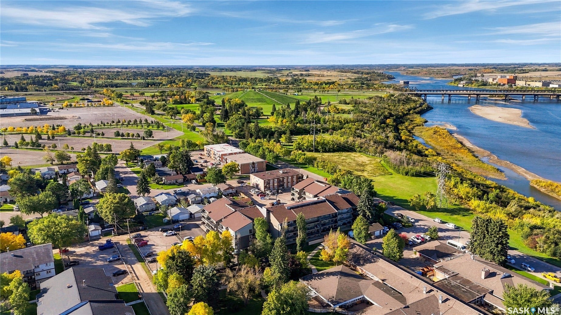 Aerial perspective capturing a river, a bridge, and surrounding green spaces