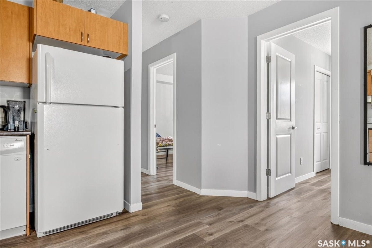 5051 James Hill Road, #107, Regina SK S4W 0B9 Wood-finish flooring throughout, complemented by a light gray wall color