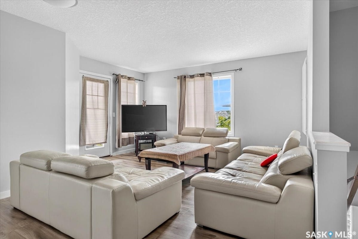 5051 James Hill Road, #107, Regina SK S4W 0B9 Wood-finish flooring, light grey wall paint, and a white ceiling