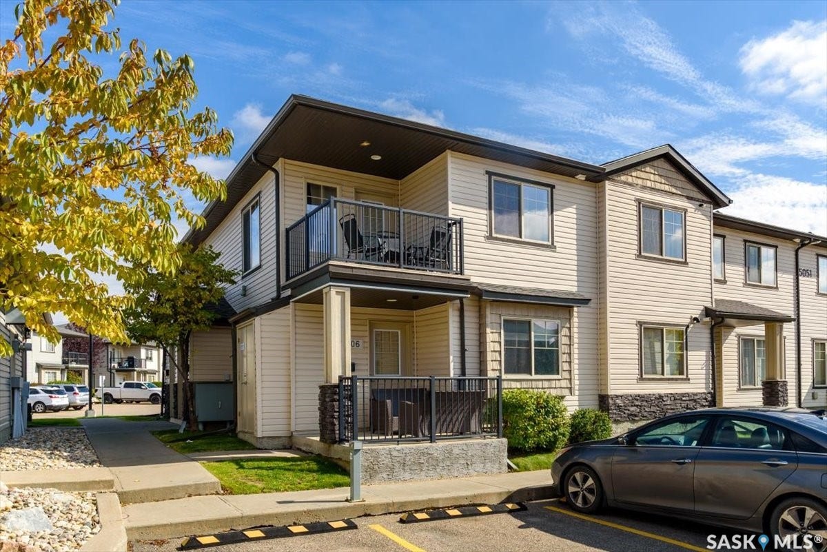 5051 James Hill Road, #107, Regina SK S4W 0B9 Two-story exterior with light-toned siding, dark trim, and a stone accent foundation