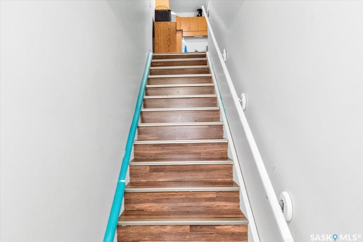5051 James Hill Road, #107, Regina SK S4W 0B9 Staircase featuring wood-finish treads with metallic risers and double handrails