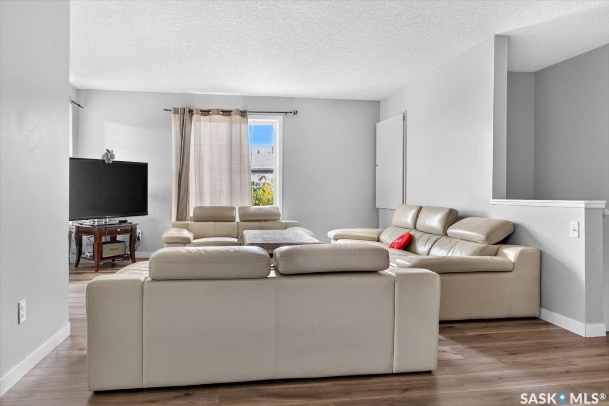 5051 James Hill Road, #107, Regina SK S4W 0B9 Wood-finish flooring, light grey wall paint, and white trim