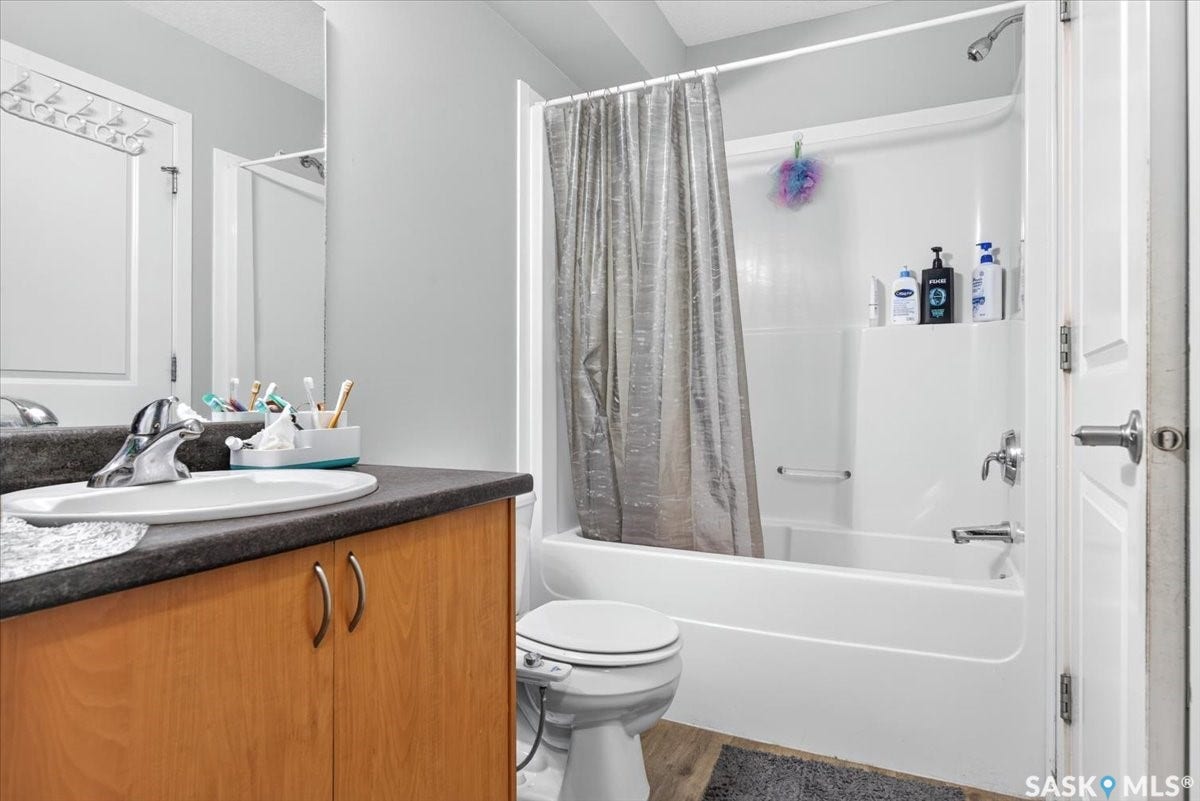 5051 James Hill Road, #107, Regina SK S4W 0B9 Wood-finish vanity with an integrated sink and chrome faucet