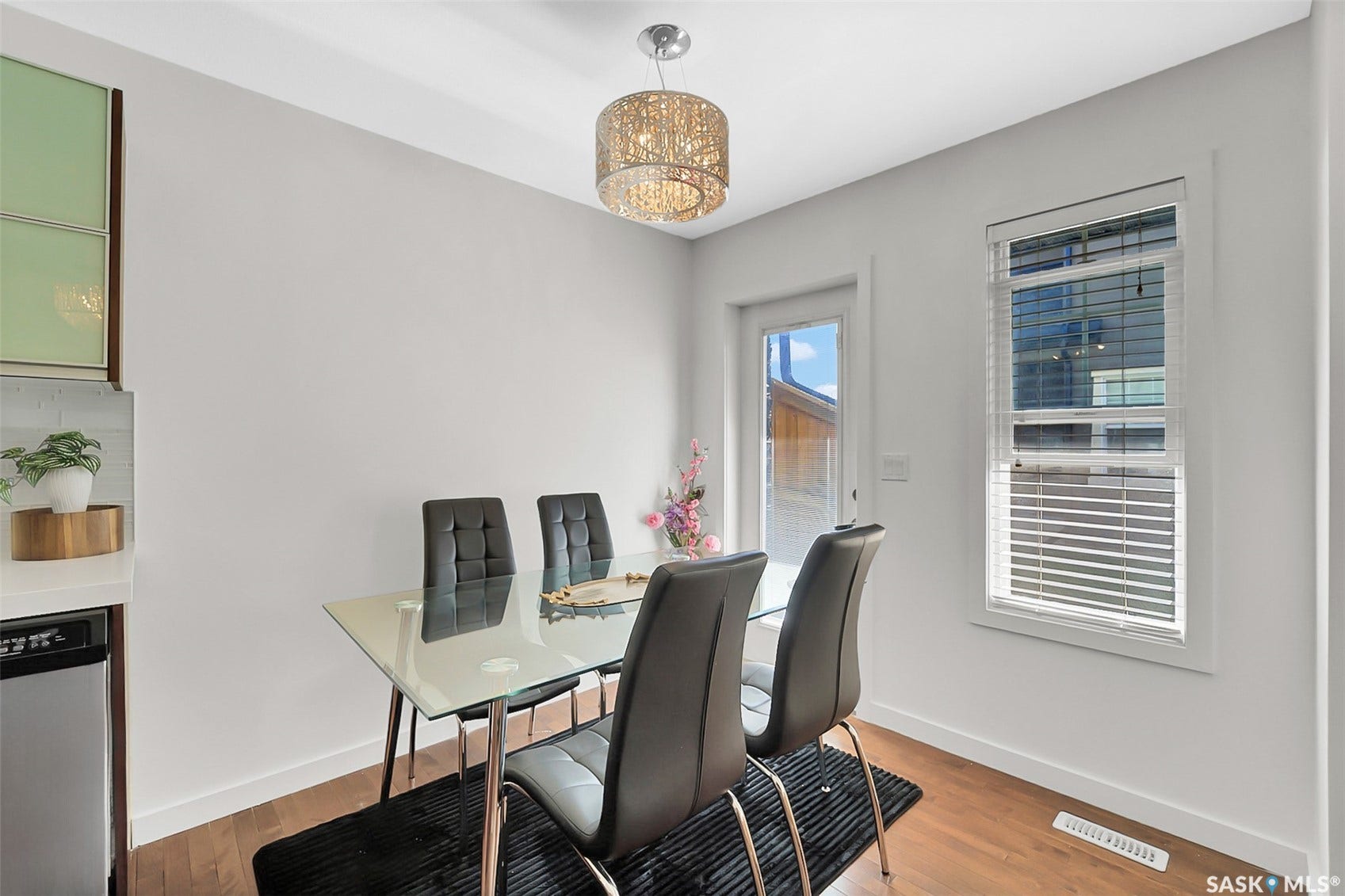 Wood-finish flooring, white walls, and a contemporary chandelier